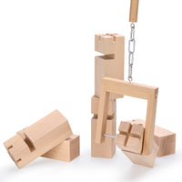 Thumbnail for Der Teamkran zieht auf diesem Bild einen Klotz an der Nut nach oben. Drumherum liegen einzelne Klötze des Fröbelturms. Zwei Klötze stehen bereits aufrecht übereinander gestapelt