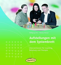 Thumbnail for Aufstellungen mit dem Systembrett - Wolfgang Polt, Dr. Markus Rimser - Hauptbild: 3. Personen schauen interessiert auf ein Systembrett. Es steht dort ebenfalls 